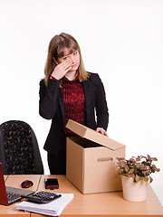 Image showing Dismissed girl in office wipes tears and collects things