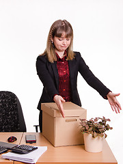 Image showing Girl in office grotyagivaet hands to indoor potted tsvutku