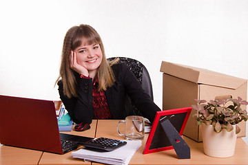 Image showing Smiling office employee sitting at the table