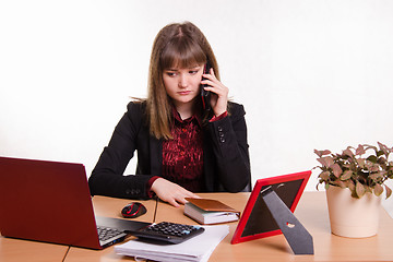 Image showing girl behind office desk on phone listening to a friend