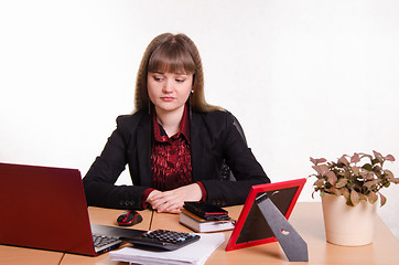 Image showing Sad girl sits at office table