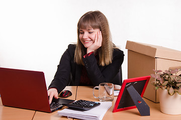 Image showing Office employee sitting at computer with a smile