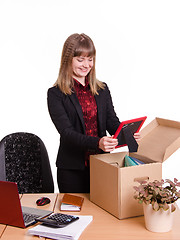 Image showing Girl puts a photo frame on desktop from box office