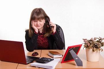 Image showing girl behind office desk listening to cry of the phone