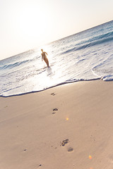 Image showing Woman running on the beach in sunset.