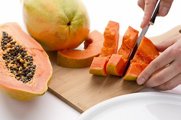 Image showing Half A Papaya Fruit Being Cut Into Slices
