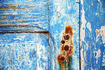 Image showing   paint in the blue wood door rusty nail