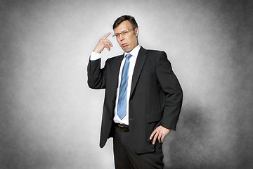 Image showing conceited business man pointing finger to head