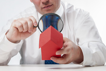 Image showing Man with a magnifying glass and paper house