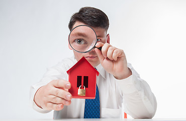 Image showing Man with a magnifying glass and paper house