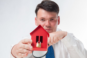 Image showing Man with a magnifying glass and paper house