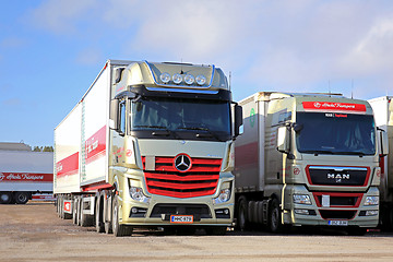 Image showing Red Mercedes-Benz Actros and MAN 2551 Trucks on a Yard