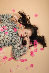 Image showing atractive brunette girl lying on beige background