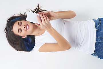 Image showing Woman lying on her back and using phone