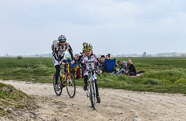 Image showing Amateur Cyclists Riding on a Cobblestoned Road