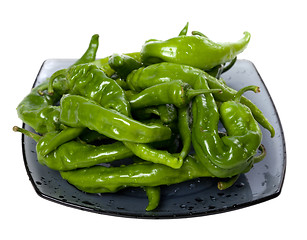 Image showing Wet green peppers on glass plate