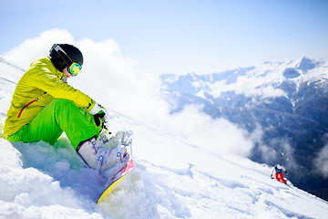 Image showing Snowboarder sitting