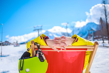 Image showing Women at mountains in winter lies on sun-lounger