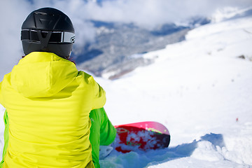 Image showing Snowboarder sitting