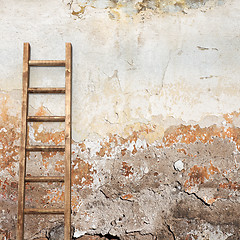 Image showing weathered stucco wall with wooden ladder