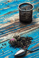 Image showing variety of dry tea leaves in jade stacks on wooden background