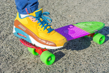 Image showing Leg skateboarder on a colorful skateboard.