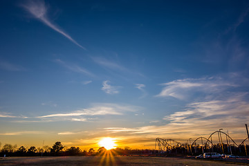 Image showing sunset over field and amusement park in distance