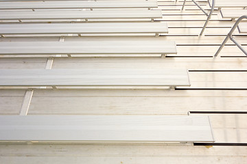 Image showing empty bleacher seating in rows, taken in a modern school sports 