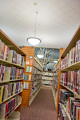 Image showing A view of rows of bookshelves and a study area inside a modern l