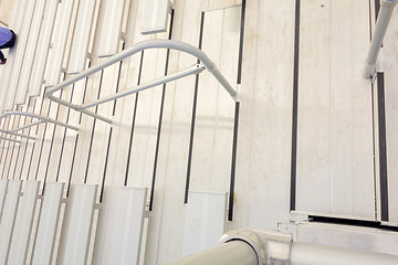 Image showing empty bleacher seating in rows, taken in a modern school sports 