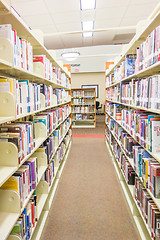 Image showing A view of rows of bookshelves and a study area inside a modern l