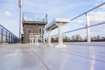 Image showing empty bleacher seating in rows, taken in a modern school sports 