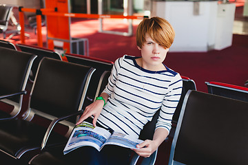 Image showing woman reading newspaper at Charles de Gaulle airport,