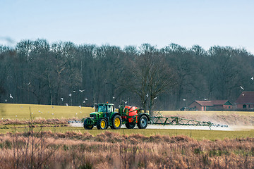 Image showing Tractor fertilizing a field