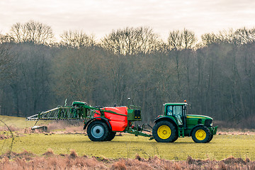 Image showing Fertilizing tractor a field