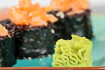 Image showing Wasabi with baked sushi rolls on turquoise plate