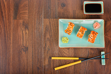 Image showing Sushi rolls on the wooden table. Top view. 