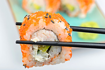 Image showing Sushi roll with black chopsticks 