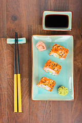 Image showing Sushi rolls on the wooden table. Aerial view. 