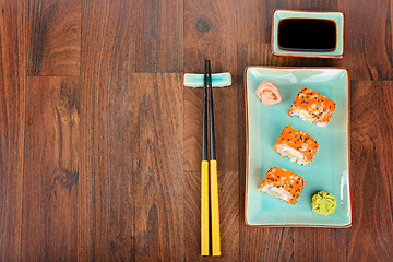 Image showing Sushi rolls on the wooden table. View from above