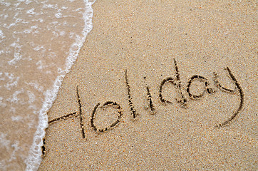 Image showing Holiday word written on sandy beach