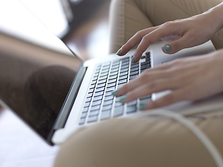 Image showing relaxed young woman at home working on laptop computer