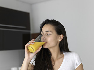 Image showing woman drinking juice in her kitchen