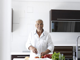 Image showing man cooking at home preparing salad in kitchen