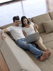 Image showing relaxed young couple working on laptop computer at home