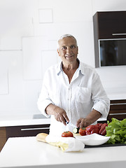 Image showing man cooking at home preparing salad in kitchen