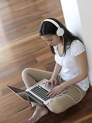 Image showing relaxed young woman at home working on laptop computer