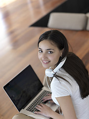 Image showing relaxed young woman at home working on laptop computer