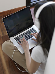 Image showing relaxed young woman at home working on laptop computer