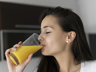 Image showing woman drinking juice in her kitchen